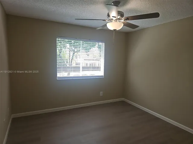 an empty room with chandelier fan