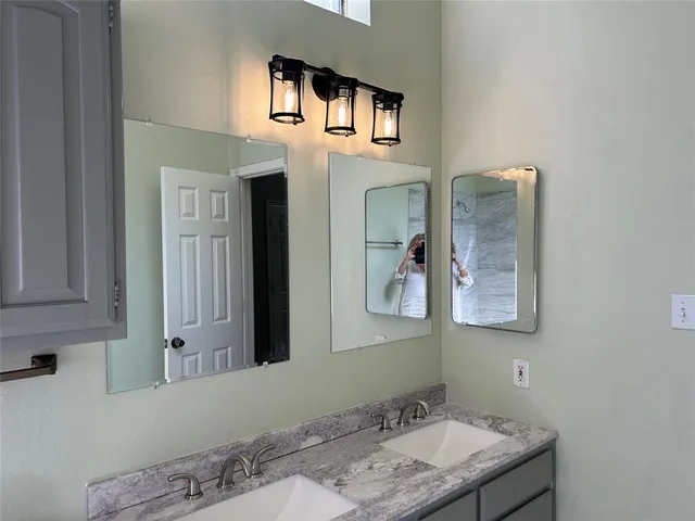 a bathroom with a granite countertop sink and a mirror