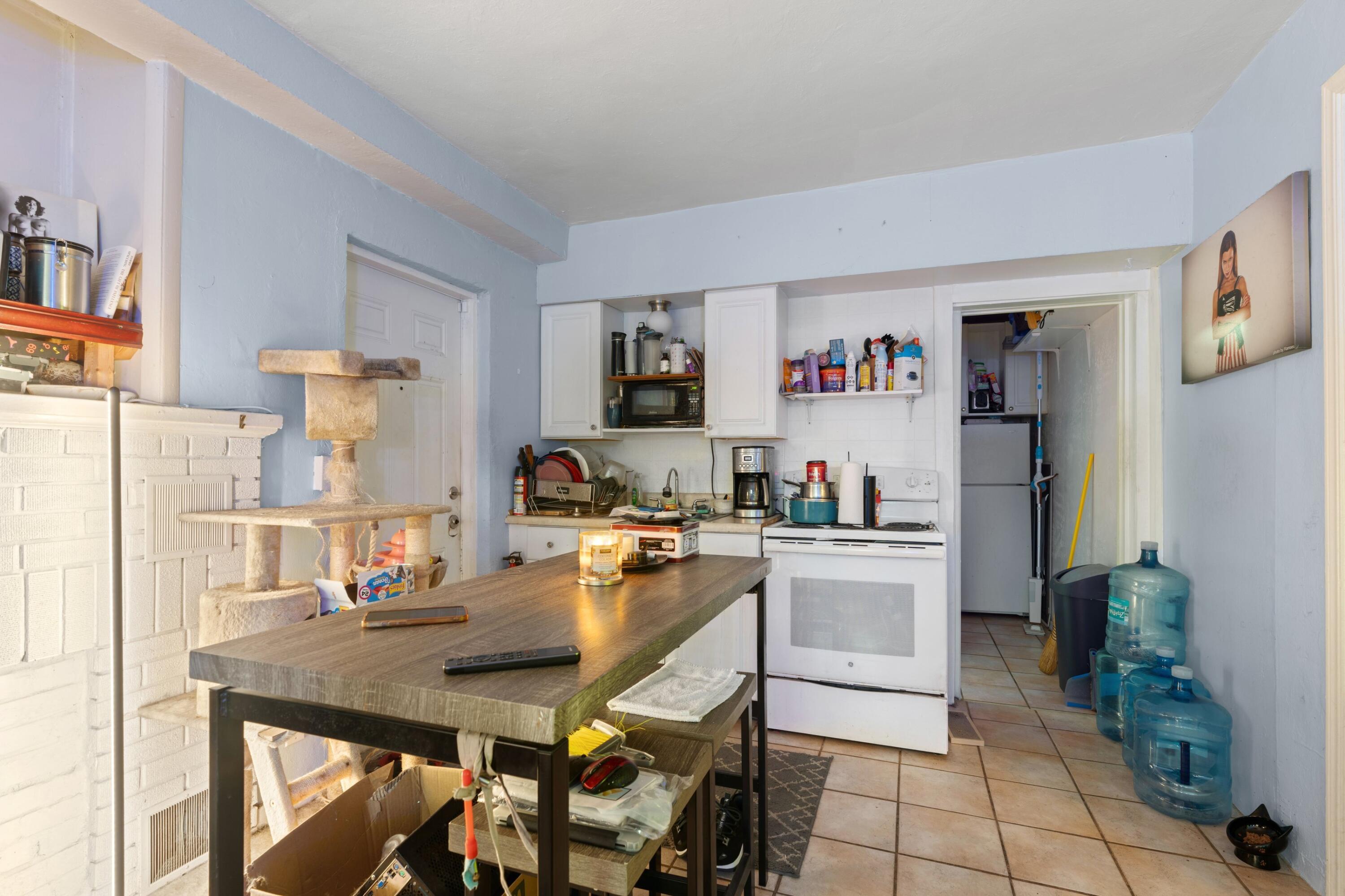 1831 Juno Road North Palm Beach, FL 33408 - Photo 20 of 37 a kitchen with a table chairs refrigerator and cabinets