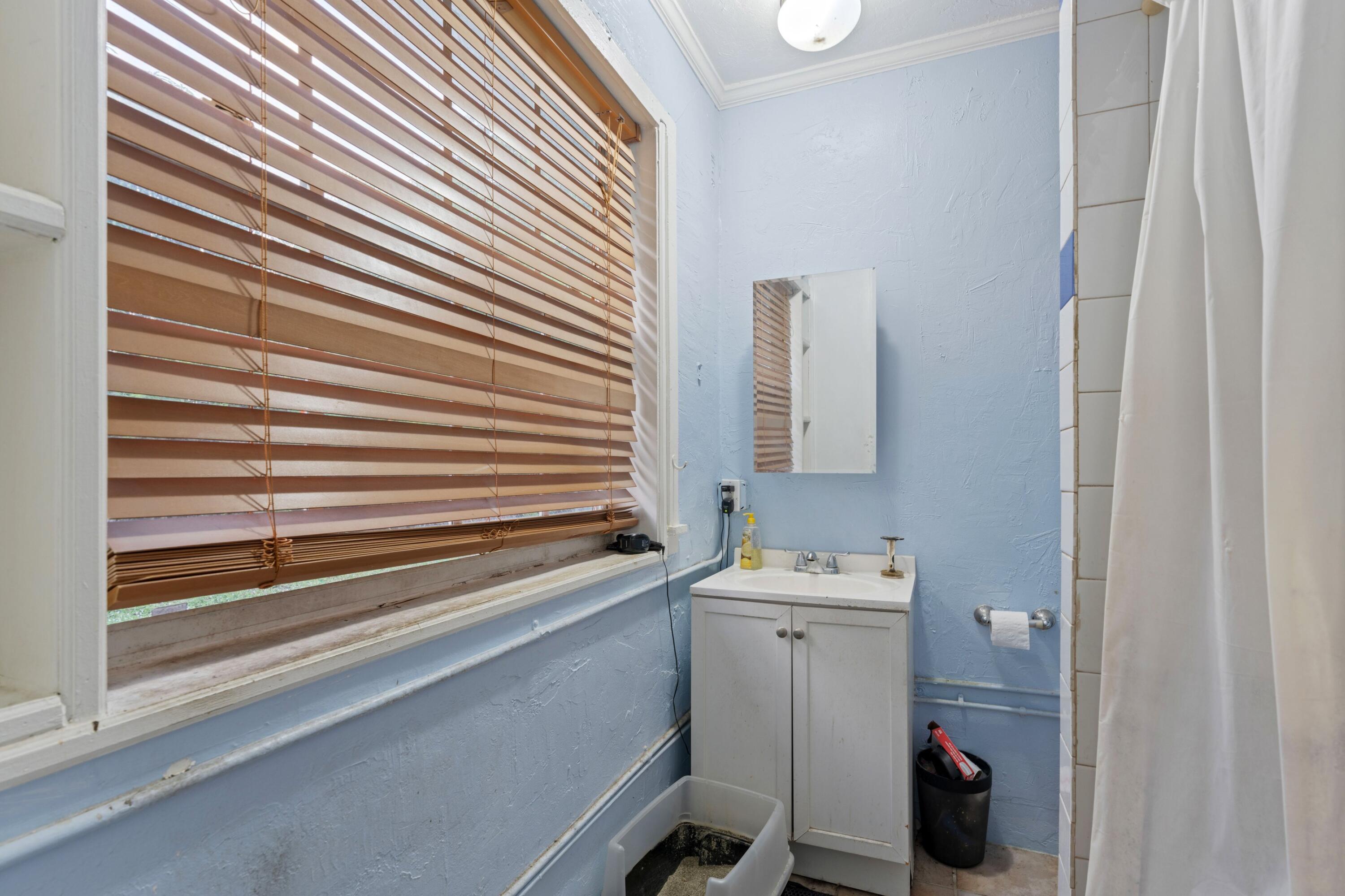 1831 Juno Road North Palm Beach, FL 33408 - Photo 23 of 37 a bathroom with a sink and a mirror
