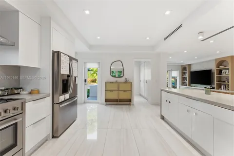 a modern kitchen with stainless steel appliances kitchen island a refrigerator and a stove top oven