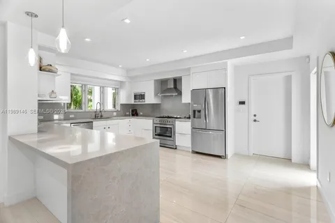 a large kitchen with kitchen island a sink stainless steel appliances and cabinets