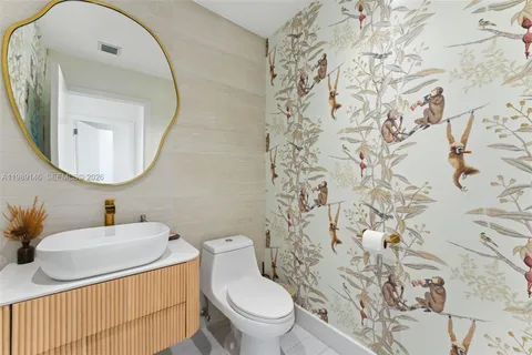 a bathroom with a toilet sink vanity and mirror