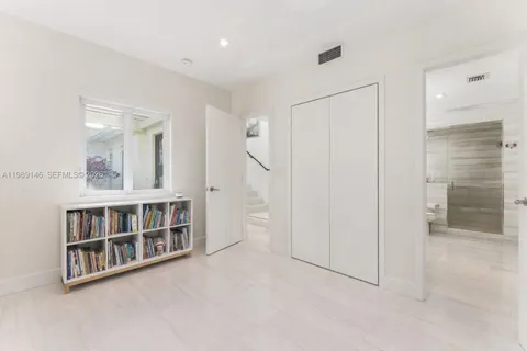 a view of empty room with a window and cabinet