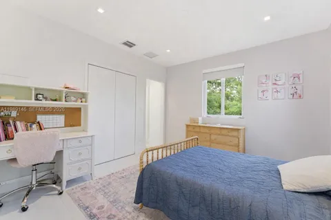 a bedroom with a bed and a chair in it