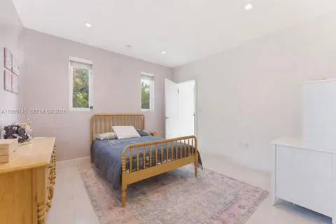 a spacious bedroom with a bed and a dresser in it
