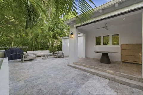 a view of backyard with a table and chairs under an umbrella