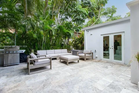 a view of a patio with couches and chairs under an umbrella
