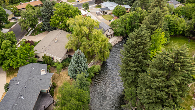 1365 Sumac Drive Logan, UT 84321 - Photo 75 of 84 Riverfront property featuring a stone and siding exterior, mature trees, a private deck, and a shingle roof