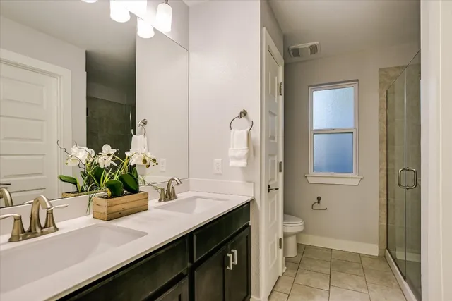 a bathroom with a sink a toilet and a large mirror