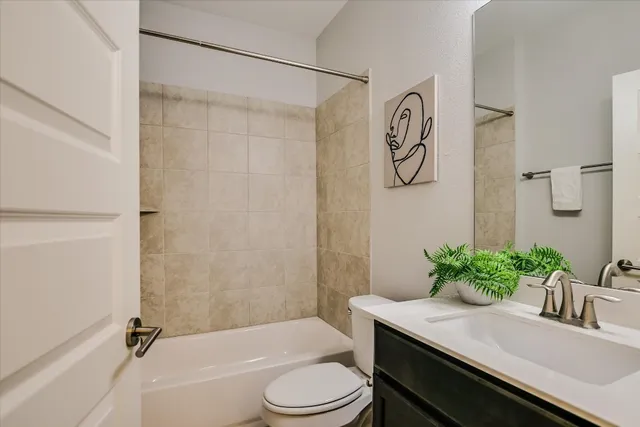 a bathroom with a granite countertop sink toilet a mirror and shower