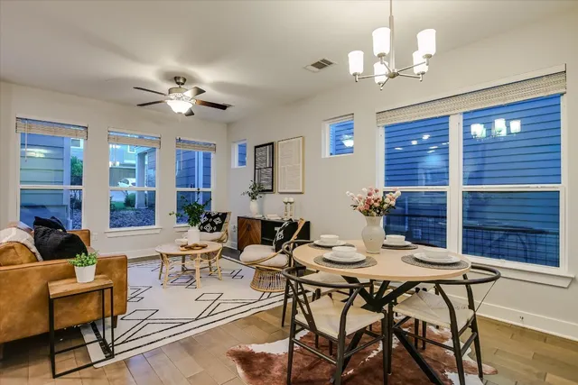 a view of a dining room with furniture a chandelier and wooden floor