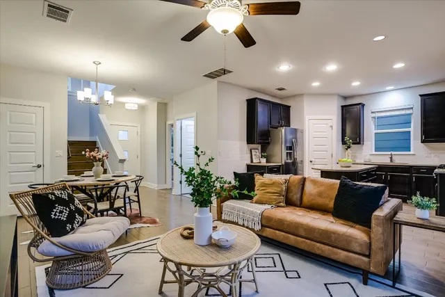 a living room with furniture kitchen view and a chandelier
