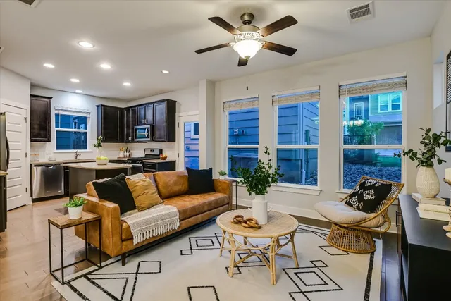 a living room with furniture kitchen view and a large window