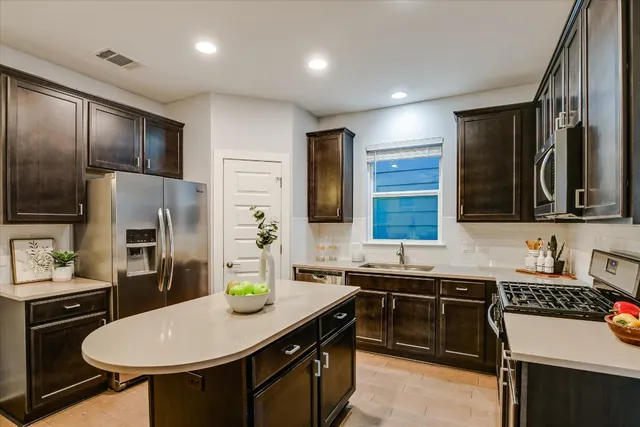 a kitchen with stainless steel appliances a sink stove and refrigerator