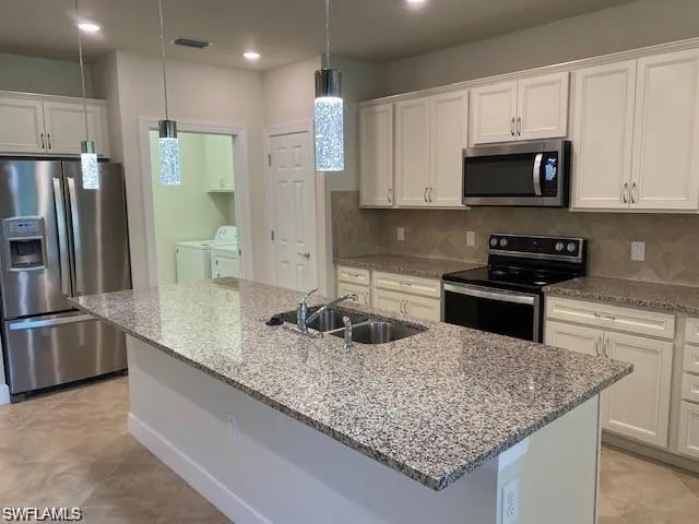 a kitchen with stainless steel appliances granite countertop a sink stove and refrigerator