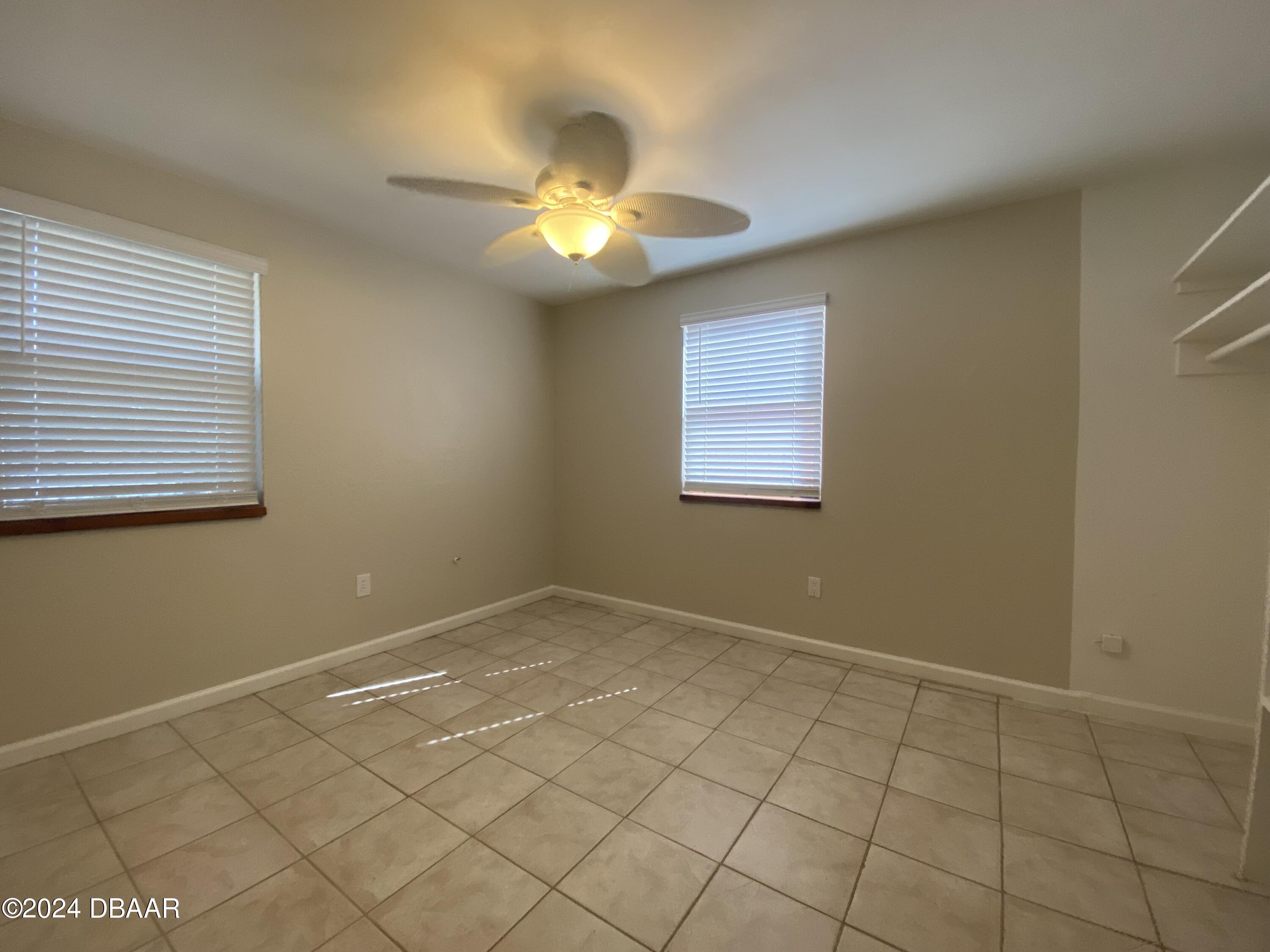 28 Rivershore Drive Ormond Beach, FL 32176 - Photo 7 of 16 an empty room with windows and fan
