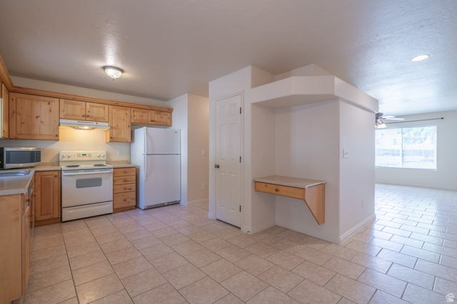 1735 West 540 North, Unit 1805 St. George, UT 84770 - Photo 19 of 64 Kitchen featuring light wood cabinetry, white appliances, light-toned tile flooring, and a built-in desk area