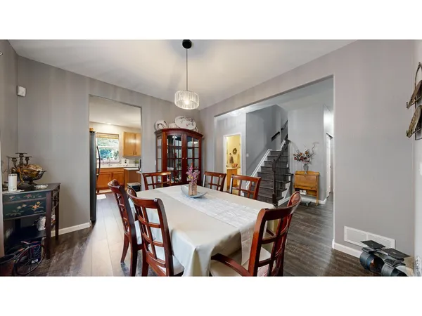 a view of dining room and livingroom with furniture wooden floor a rug a painting and a chandelier