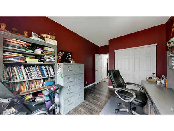 a living room with furniture a bookshelf and a flat screen tv