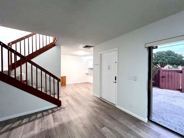 a view of a hallway with wooden floor and stairs