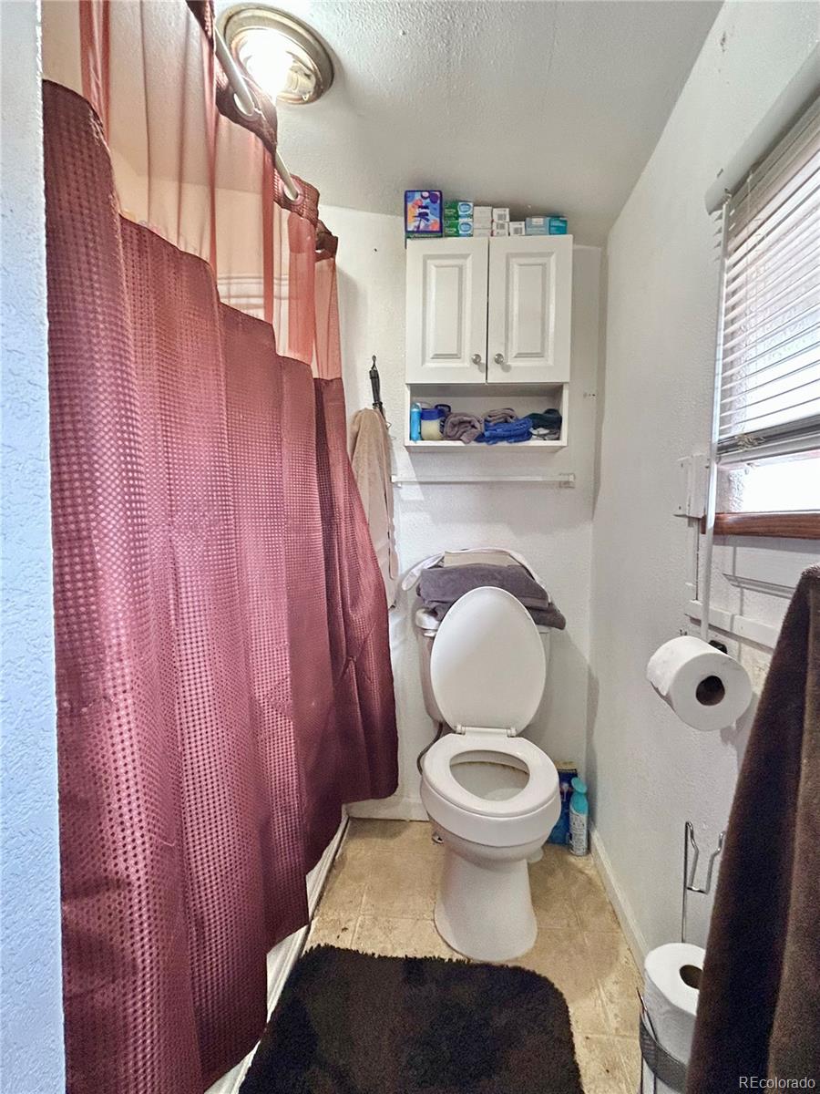 26 West 3rd Street Walsenburg, CO 81089 - Photo 11 of 27 a bathroom with a toilet a sink and a window