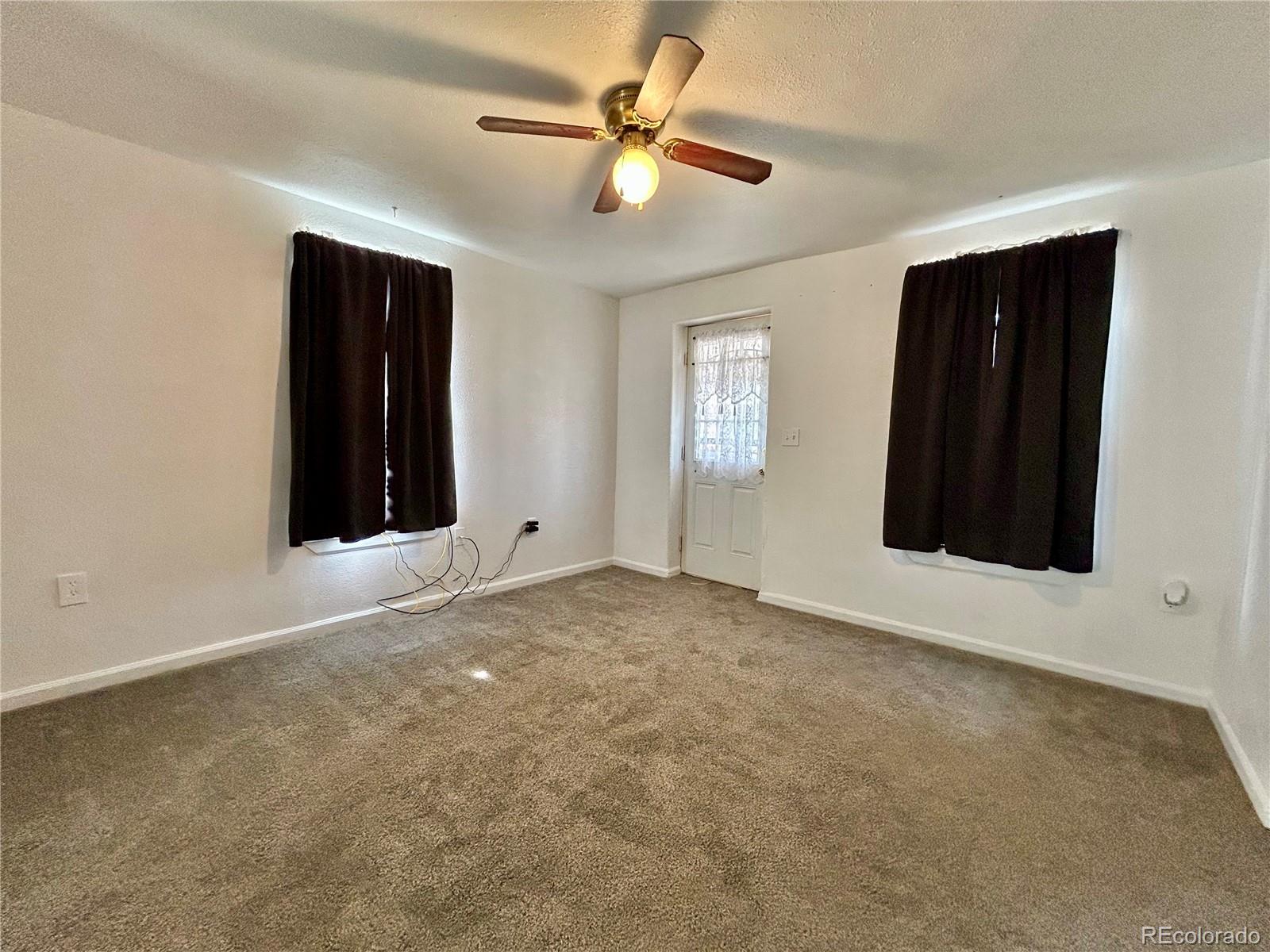 26 West 3rd Street Walsenburg, CO 81089 - Photo 9 of 27 an empty room with ceiling fan and window