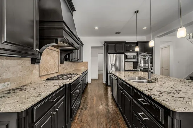 a large kitchen with granite countertop a stove and a sink