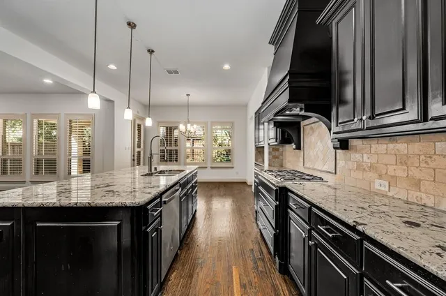 a kitchen with stainless steel appliances granite countertop a sink and stove
