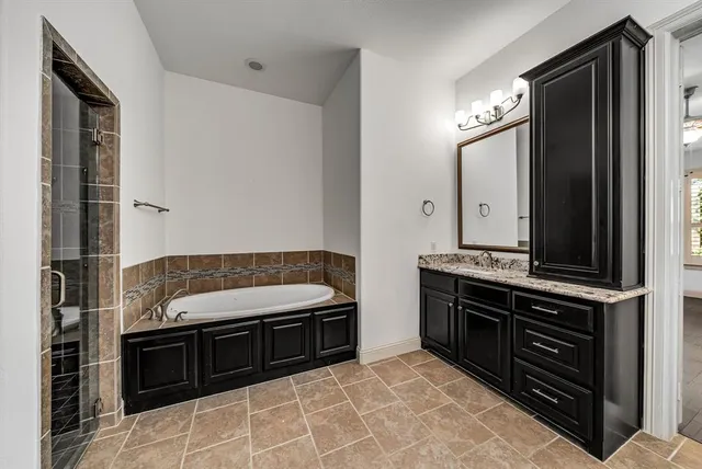 a bathroom with a tub sink and mirror
