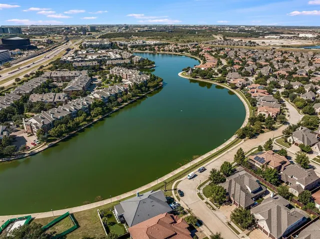 an aerial view of city and lake with trees all around