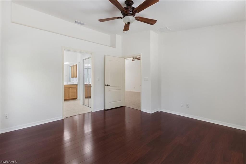 15073 Cortona Way Naples, FL 34120 - Photo 20 of 35 an empty room with wooden floor fan and windows