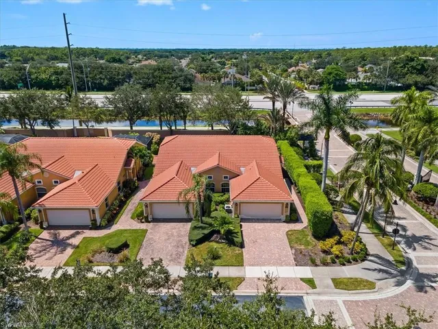 an aerial view of residential houses with outdoor space and lake view