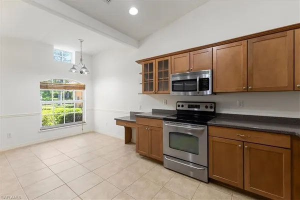 a kitchen with stainless steel appliances granite countertop a stove a microwave and a sink