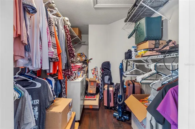 a view of walk in closet with clothes and shoes