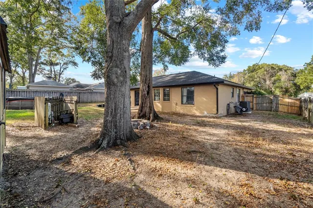 a view of a house with backyard and tree