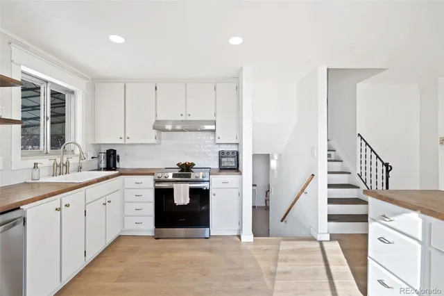 a view of a bedroom with wooden floor and a ceiling fan