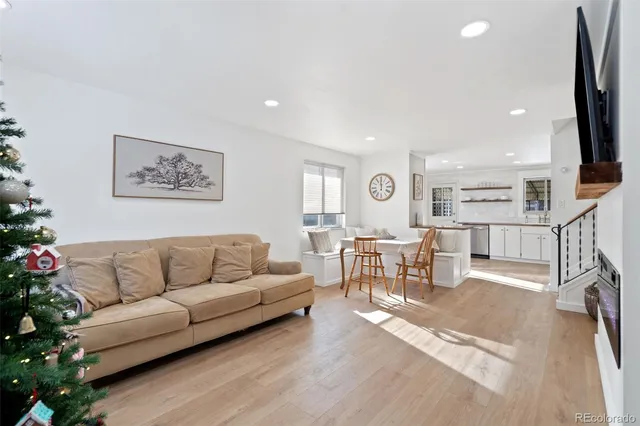 a living room with furniture kitchen view and a large window