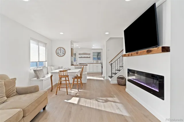 a kitchen with stainless steel appliances granite countertop a stove a sink and white cabinets with wooden floor