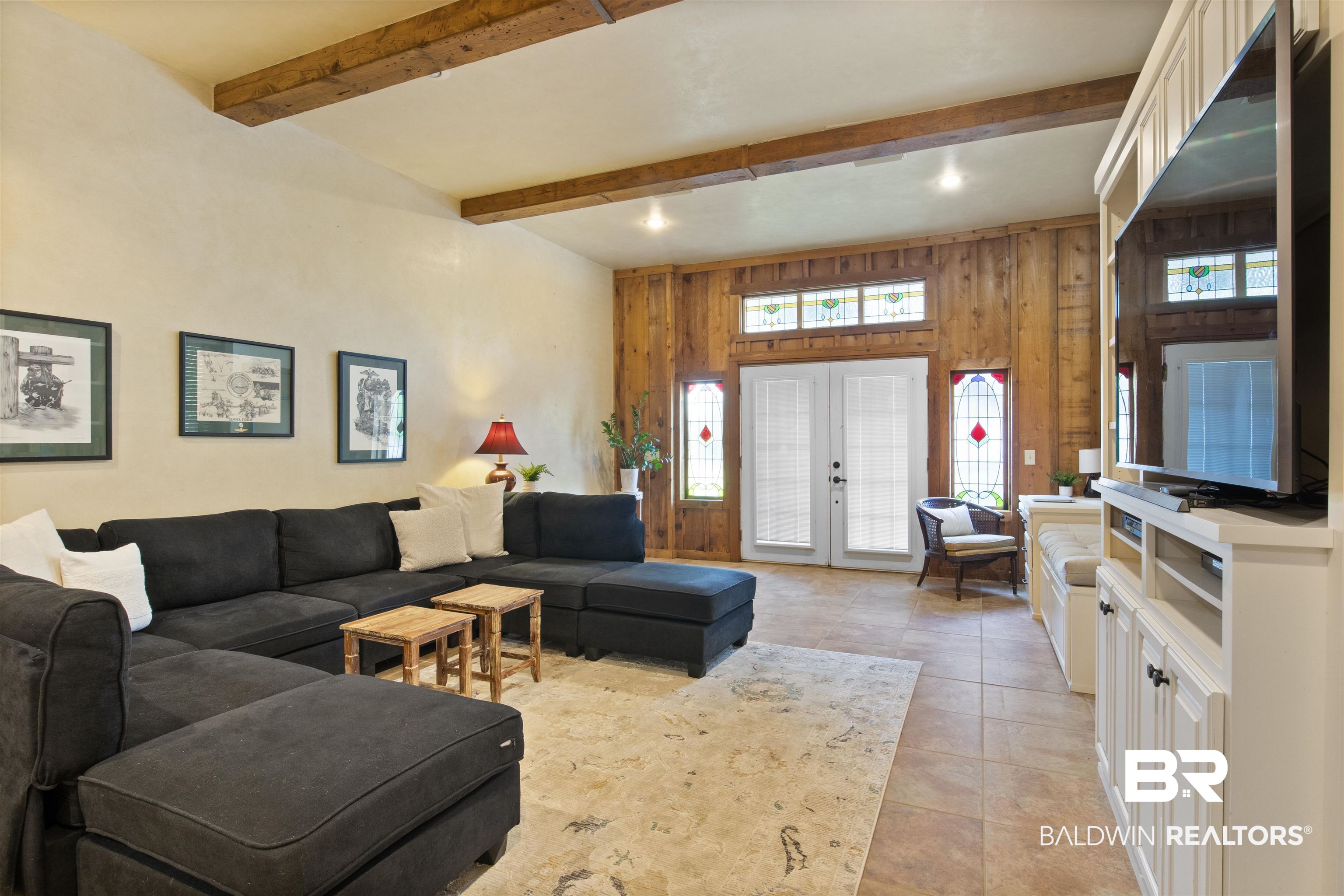 15100 Vasko Road Silverhill, AL 36576 - Photo 6 of 51 Living room with wood walls, light tile patterned floors, beamed ceiling, and french doors leading to porch and pool. Extra pantries/storage and laundry also located in this space.