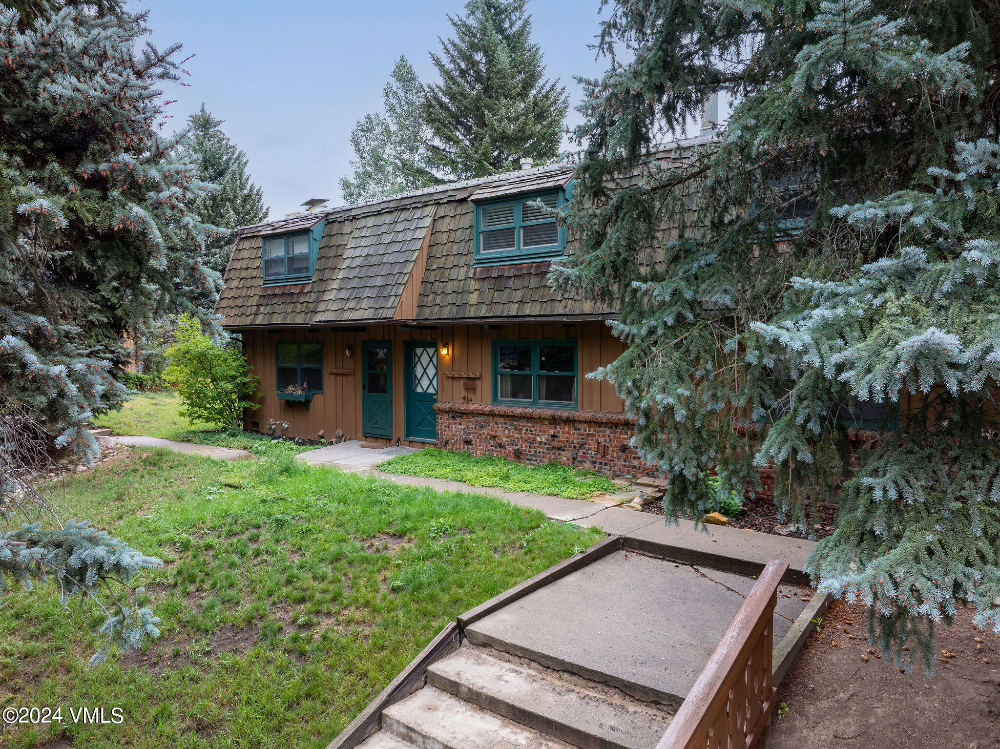 2456 Chamonix Lane, Unit B2 Vail, CO 81657 - Photo 14 of 18 a view of a backyard with plants and large tree