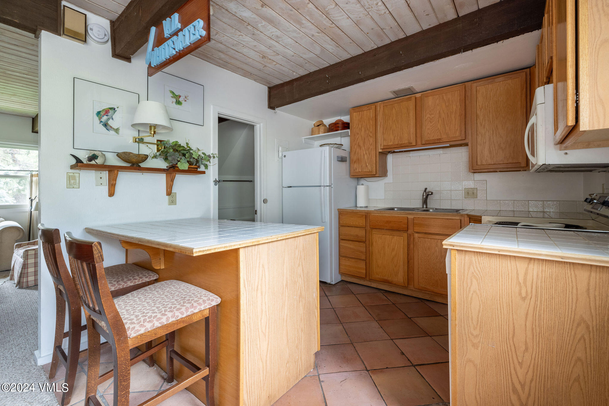 2456 Chamonix Lane, Unit B2 Vail, CO 81657 - Photo 5 of 18 a kitchen with a table chairs and a refrigerator