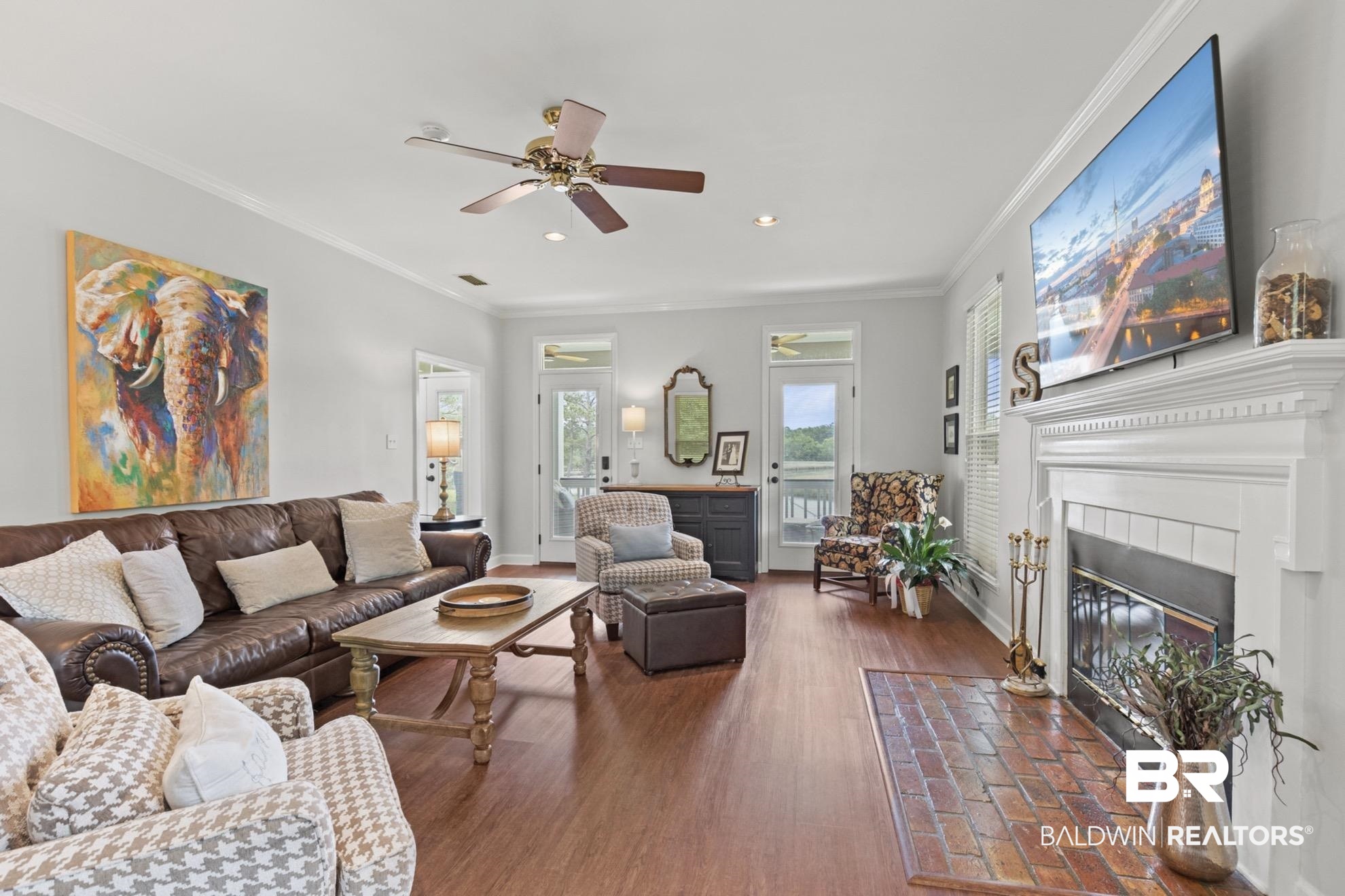 12171 Marguerite Drive Coden, AL 36523 - Photo 5 of 44 Spacious living area featuring wood-finish flooring, a traditional white mantel fireplace with a tile hearth, and crown molding