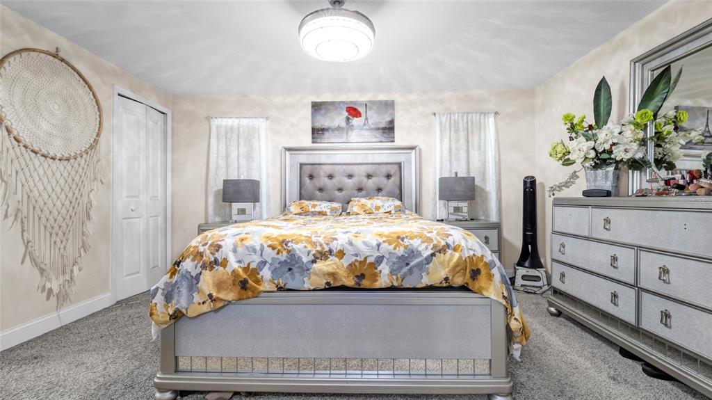 500 Hillpine Way Brandon, FL 33510 - Photo 18 of 39 a bed sitting in a bedroom next to a window with potted plants