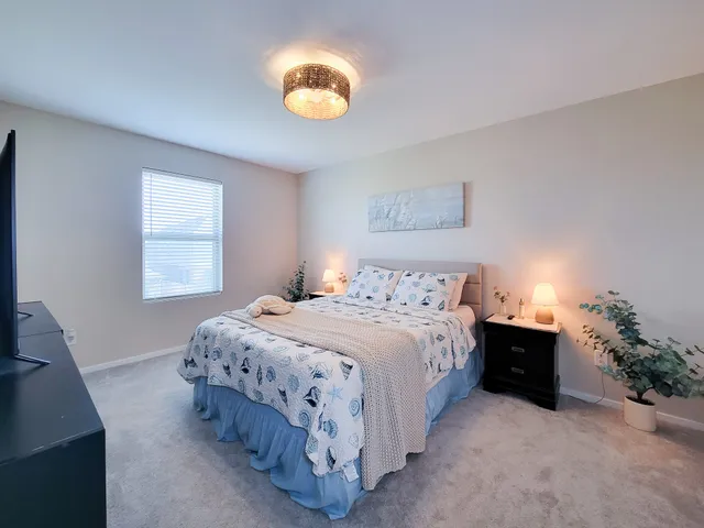 a bedroom with a bed and painting on the wall