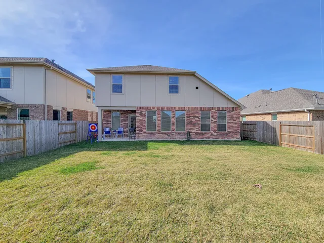 a view of a house with a yard and sitting area