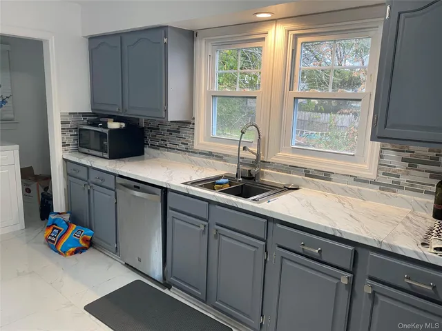 a kitchen with stainless steel appliances granite countertop a sink a stove and a microwave