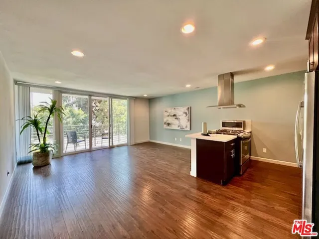 a kitchen with a sink and wooden floor