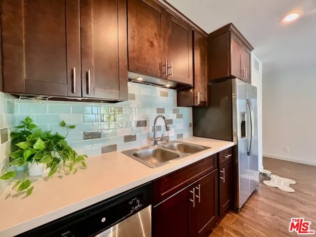 a kitchen with stainless steel appliances a sink stove and cabinets