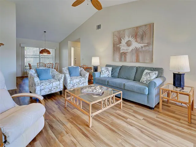 a kitchen with kitchen island a sink a stove a refrigerator cabinets and dining table